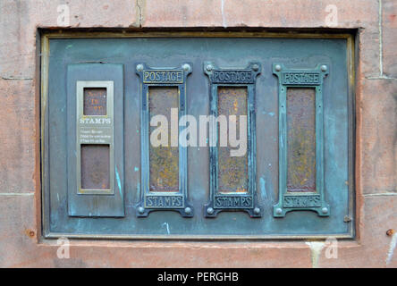 Alte Post vending Stempel Maschinen Fronten in einer sandsteinmauer Inset Stockfoto