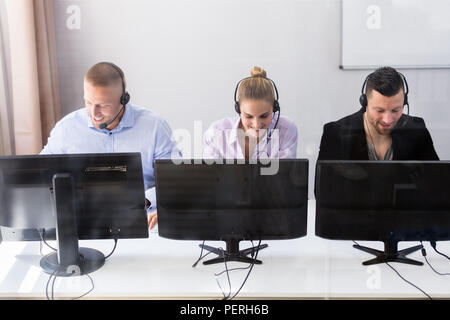 Junge Kundenservice Führungskräfte mit Ohrhörer Arbeiten im Call Center Stockfoto