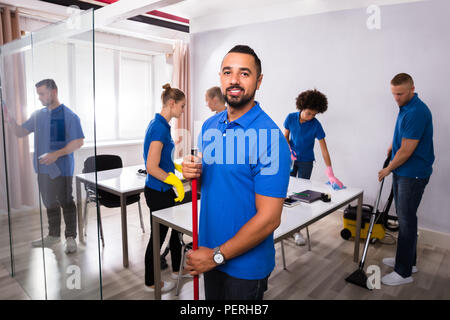 Portrait eines glücklichen Männlichen Hausmeister in Office Stockfoto