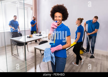 Porträt eines lächelnden Afrikanische Frauen Hausmeister Holding Tuch und Sprühflasche Stockfoto
