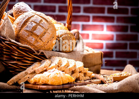 Noch immer leben Foto von Brot und Backwaren im Weidenkorb. Amerikanische und französische Toast zum Frühstück. Stockfoto