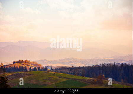 Hazy Abend in den Bergen. schöne Landschaft im Herbst. warmes Wetter mit rosa Wolken am Himmel Stockfoto