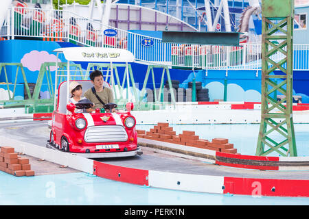 TOKYO, Japan - 19. Juli 2016 - Japanische Vater und seine tochter genießen Sie Ihre Zeit zusammen reiten auf einem Furi Furi GP Auto im Tokyo Dome City Amusement Park i Stockfoto