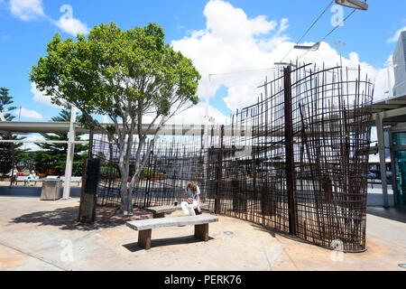 Junge Frau vor Kunstwerken außerhalb von Sydney Kingsford-Smith International Airport, New South Wales, NSW, Australien sitzen Stockfoto