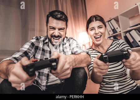 Begeistert Frau und Mann spielt ein Video Spiel Stockfoto
