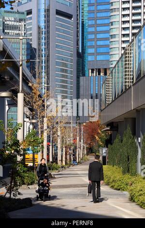 Tokio, Japan - Dezember 2, 2016: Menschen laufen unter Schwebebahn Eisenbahn in Shiodome Bezirk in Tokio. Tokyo ist die Hauptstadt von Japan. Stockfoto