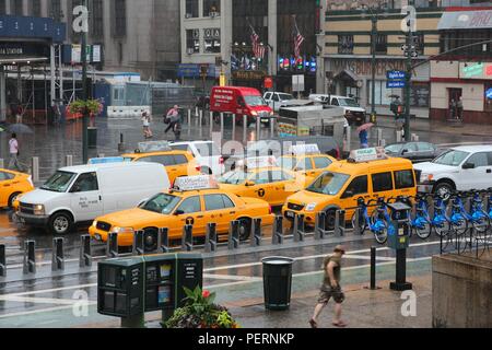 NEW YORK - 1 JULI: Leute laufen Sie entlang der regnerischen 8th Avenue am 1. Juli 2013 in New York. Fast 19 Millionen Menschen leben in New York City metropolitan area. Stockfoto