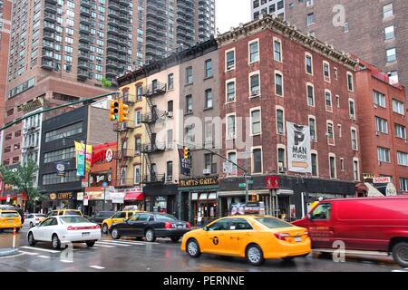 NEW YORK, VEREINIGTE STAATEN - 10. JUNI 2013: Taxis fahren Sie entlang der regnerischen 8th Avenue in New York. Fast 19 Millionen Menschen leben in New York City Metropolitan ein Stockfoto