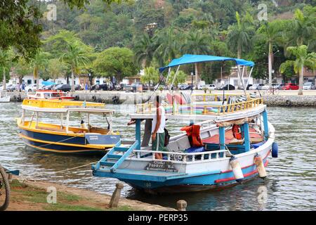 PARATY, Brasilien - 14. OKTOBER 2014: Person steht auf bunten Boot in Paraty (Bundesstaat Rio de Janeiro). Die koloniale Stadt reicht bis ins Jahr 1667 zurück und ist Con Stockfoto