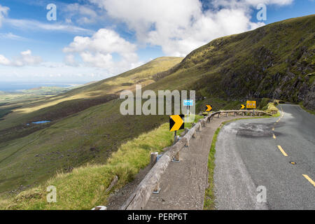 Touring Autofahrer überqueren Sie die Berge der Halbinsel Dingle in Irland auf der schmalen, gewundenen Conor Pass Road. Stockfoto