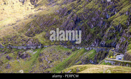 Touring Autofahrer überqueren Sie die Berge der Halbinsel Dingle in Irland auf der schmalen, gewundenen Conor Pass Road. Stockfoto
