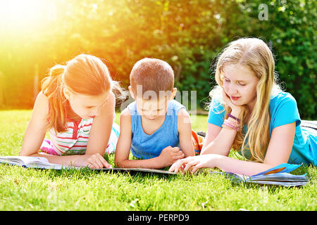 Freunde Bücher lesen outdoori auf Gras im Sommer Tag Stockfoto