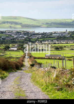 Ein Stein, Anschluss, früher die Hauptstraße nach Conor Pass, klettert Conor Hügel von Dingle Town, mit Dingle Harbour hinter, in der irischen Grafschaft Kerry. Stockfoto