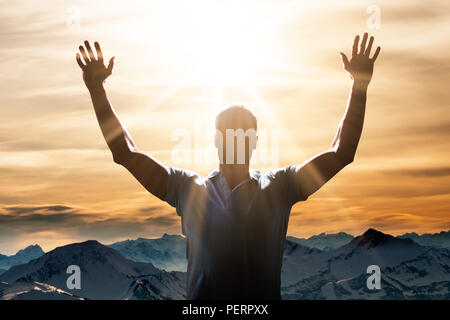 Mann hob seinen Arm vor Berglandschaft Stockfoto