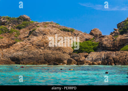 Schöne Landschaft mit blauer Himmel, türkisfarbenes Wasser & Touristen Schnorcheln vor der hoch aufragenden Felsen Felsen von redwitz Burung (Bird Island), ein beliebter ... Stockfoto