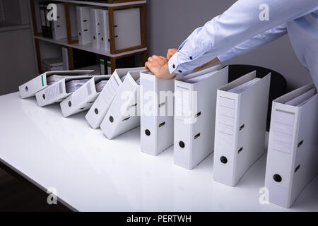 Mann Stoppen der Dateien auf dem Schreibtisch im Büro Stockfoto