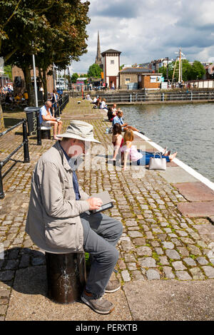 Großbritannien, England, Bristol, Hafen, mann lesen Kindle e-Reader am Kai außerhalb Arnolfini Galerie Stockfoto