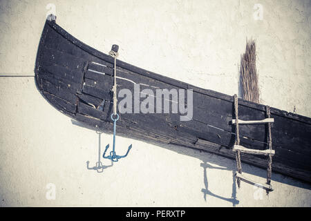 Eine alte verlassene Holz- Boot auf einer Wand angezeigt. Stockfoto