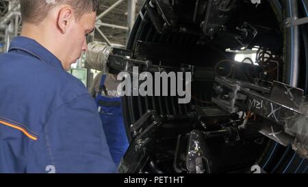 Russland, ANGARSKER - Juni 8, 2018: Rollen einfädeln Spule anbringen. Herstellung von Wasserleitungen aus Kunststoff Fabrik. Prozess, in dem die Kunststoffe an der Werkzeugmaschine mit der Nutzung von Wasser- und Luftdruck. Stockfoto