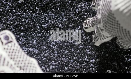 Kunststoff schwarz grau granulierten Crumb. Herstellung von Wasserleitungen aus Kunststoff Fabrik. Prozess, in dem die Kunststoffe an der Werkzeugmaschine mit der Nutzung von Wasser- und Luftdruck. Stockfoto