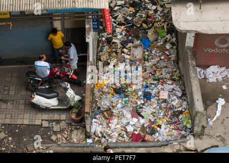 Große Haufen Plastikmüll und anderen Müll zwischen kommerziellen Gebäuden in Asalpha, Mumbai, Indien sitzen Stockfoto