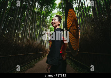 Schönen japanischen ältere Frau zu Fuß im Bambuswald Stockfoto