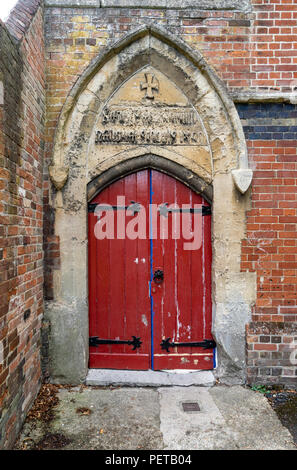 Alten roten Doppeltür in steinernen Torbogen Stockfoto