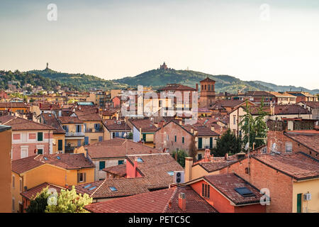 Bologna, Emilia Romagna, Italien. Die Dächer der Stadt bei Sonnenuntergang: Basilika von San Luca im Hintergrund. Stockfoto