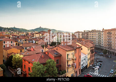 Bologna, Emilia Romagna, Italien. Die Dächer der Stadt bei Sonnenuntergang: Basilika von San Luca im Hintergrund. Stockfoto