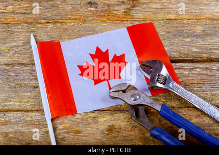 Kanadische Flagge Tag der Arbeit Schraubenschlüssel Ingenieur Konstruktor Tools auf einem denim Arbeiter, Konstrukteur Werkzeuge Holz- Hintergrund Stockfoto