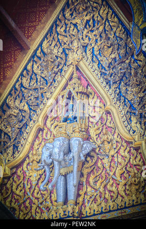 Schöne Skulptur des Engels, der auf drei Köpfe Elefanten auf der Giebelseite des Buddhistischen Kirche in thailändischen Tempel. Stockfoto