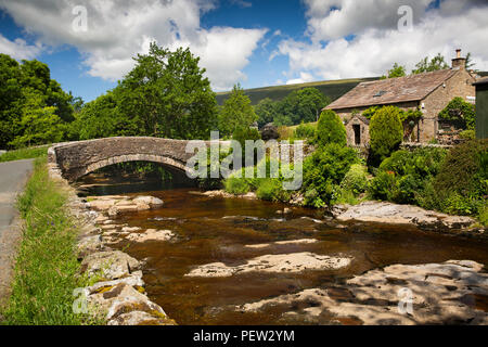 UK, Cumbria, Dentdale, Cowgill, Haus neben alten steinernen Brücke über den Fluss Dent Stockfoto