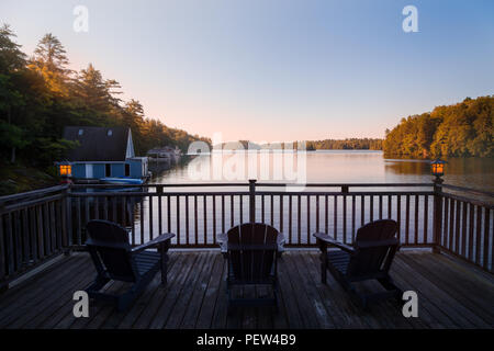 Trio von Muskoka Stühle auf der Terrasse mit Blick auf See Joseph in der Morgendämmerung. Stockfoto