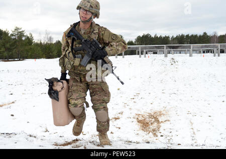 Pfc. Justin Liles, ein M1127 Stryker Reconnaissance Vehicle Treiber mit der 3. Staffel, 2. Kavallerie Regiments, aus Vilseck, Deutschland stationiert, ursprünglich von Lumberton, N.C., trägt ein 5-Liter Behälter mit Wasser ein 8-Fuß berm während eines Stress schießen Übung in Adazi Training Area in Lettland, Feb 1, 2016 gefüllt. Stockfoto