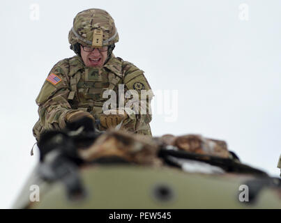 Sgt. Jeremia Ortiz, ein M1127 Stryker Reconnaissance Vehicle Commander mit der 3. Staffel, 2. Kavallerie Regiments, aus Vilseck, Deutschland stationiert, ursprünglich aus Orem, Utah, drückt aus, wie schwierig es ist, eine medizinische, zum automatischen Scharfschalten Stretcher mit Logs gefüllt bei einem Stress schießen Übung in Adazi Training Area in Lettland, Feb 1, 2016 Ein 8-Fuß berm ziehen. Stockfoto