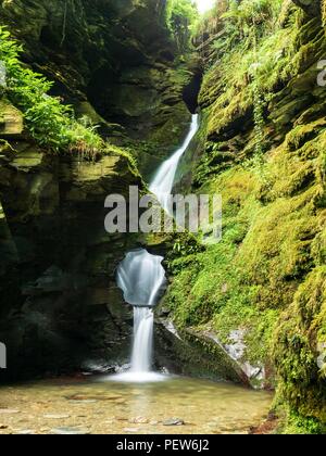 Ein Wasserfall durch ein Loch im Fels im St nectan's Glen in Cornwall. Stockfoto
