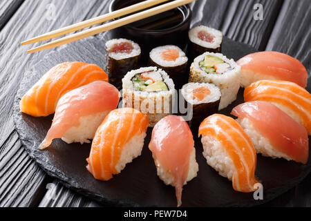 Sushi Rollen auf schwarzen Stein Schiefer auf dunklem Hintergrund serviert. Ein japanisches Menü Stockfoto