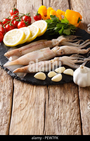 Frischer Tintenfisch oder Tintenfische raw auf Schiefer mit Zutaten Nahaufnahme auf dem Tisch. Vertikale Stockfoto
