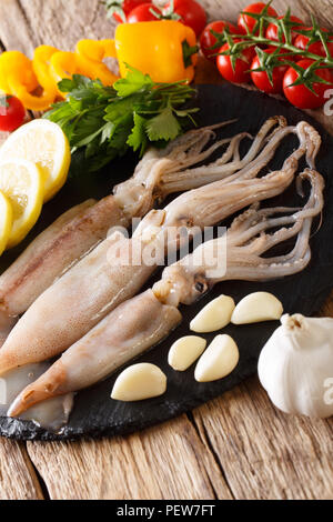 Meeresfrüchte frische Tintenfische mit Tentakeln close-up und Gemüse für die Küche auf den Tisch. Vertikale Stockfoto