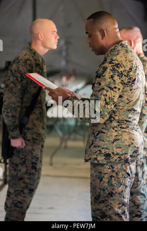 Us Marine Corps Sgt. Maj. Devon A. Lee, Camp Hansen Sergeant Major, liest eine Förderung rechtfertigen während einer verdienstvollen Förderung Zeremonie als Teil der Kommandostellenübung (CPX) 16 auf Okinawa, Japan, Feb 2, 2016. CPX 16 durchgeführt, um die Fähigkeiten des III MEF in Intelligenz und logistische Abläufe zu verbessern, die künftige Planung und Bekämpfung der Bereitschaft. (U.S. Marine Corps Foto von MCIPAC bekämpfen Kamera Lance Cpl. Damon A. Mclean/Freigegeben) Stockfoto