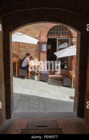 Eine junge Paar sitzt auf der Terrasse des Restaurant & Wine Bar Zest auf einem steilen kleine Straße in Siena, Italien Stockfoto