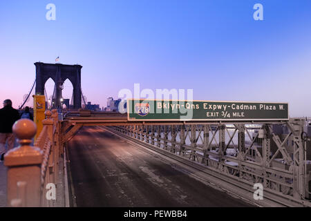 Querformat der Brooklyn Bridge in Manhattan, Schuß an den Sonnenaufgang mit einem Schild in den Vordergrund und Brooklyn im Hintergrund Stockfoto