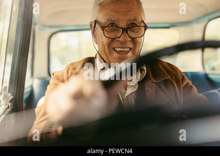 Gerne älterer Mann mit Brille Auto fahren. Gerne alte Mann mit seinem Auto fährt. Stockfoto