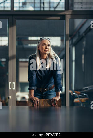 Portrait von zuversichtlich reife Geschäftsfrau im Board Room und weg schauen. Erfolgreiche weibliche Unternehmer im Büro. Stockfoto