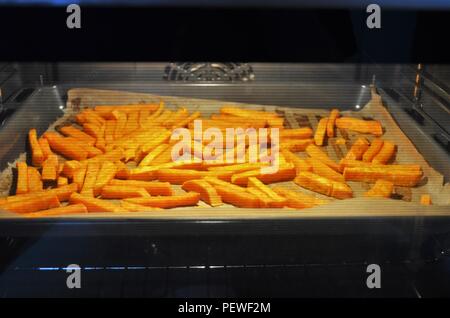 Handcut sweetpotato Pommes Frites sind Backen im Ofen Stockfoto