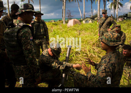 Us Marine Corps Gilbert ChavezMoreno, Recht, ein Mörser Mann mit 2Nd Battalion, 4th Marine Regiment, erläutert die Funktionen des M224 60 mm Mörser System ein malaysischer Soldat bei der Landung Kraft Zusammenarbeit flott Bereitschaft und Weiterbildung (LF KARAT) 2015 Tanduo Strand, Sabah, Malaysia, 15 August, 2015. LF CARAT ist dazu gedacht, zu stärken, die die Interoperabilität der amphibischen Planung und Betrieb und die zentralen Fähigkeiten zwischen den Vereinigten Staaten und den Ländern Indonesien, Malaysia und Thailand. (U.S. Marine Corps Foto von MCIPAC bekämpfen Kamera Lance Cpl. Sergio RamirezRomero/ Stockfoto