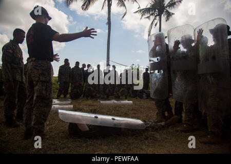 Us Marine Corps Sgt. Garrett Spino, Links, einem truppführer mit Golf Company, 2nd Battalion, 4th Marine Regiment, erklärt ein Mann unten bohren den malaysischen Soldaten während der Durchführung einer riot control Bohren bei der Landung Kraft Zusammenarbeit flott Bereitschaft und Weiterbildung (LF KARAT) 2015 Tanduo Strand, Sabah, Malaysia, Nov. 16, 2015. LF CARAT ist dazu gedacht, zu stärken, die die Interoperabilität der amphibischen Planung und Betrieb und die zentralen Fähigkeiten zwischen den Vereinigten Staaten und den Ländern Indonesien, Malaysia und Thailand. (U.S. Marine Corps Foto von MCIPAC bekämpfen Kamera Lance Cpl. Se Stockfoto