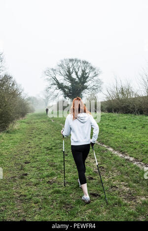 Junge Frau mit langen roten Haaren Sportkleidung tragen, beim Sport im Freien. Stockfoto