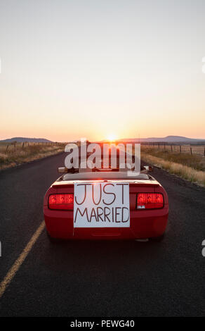 Ein älteres Paar 'Just Married' Reiten in einem Cabrio Sportwagen im östlichen Staat Washington, USA. Stockfoto