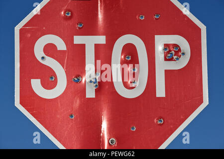 Ein stoppschild, die mehrere Male mit einem Gewehr geschossen wurde. Stockfoto